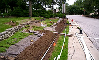 An open trench with irrigation pipe run across a landscaped slope
